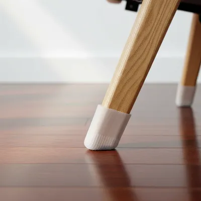 A recliner chair leg with a clear silicone furniture cup gripping a hardwood floor, illustrating stability and floor protection.